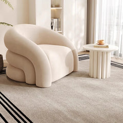 Modern beige lounge chair in minimalist living room with curved design