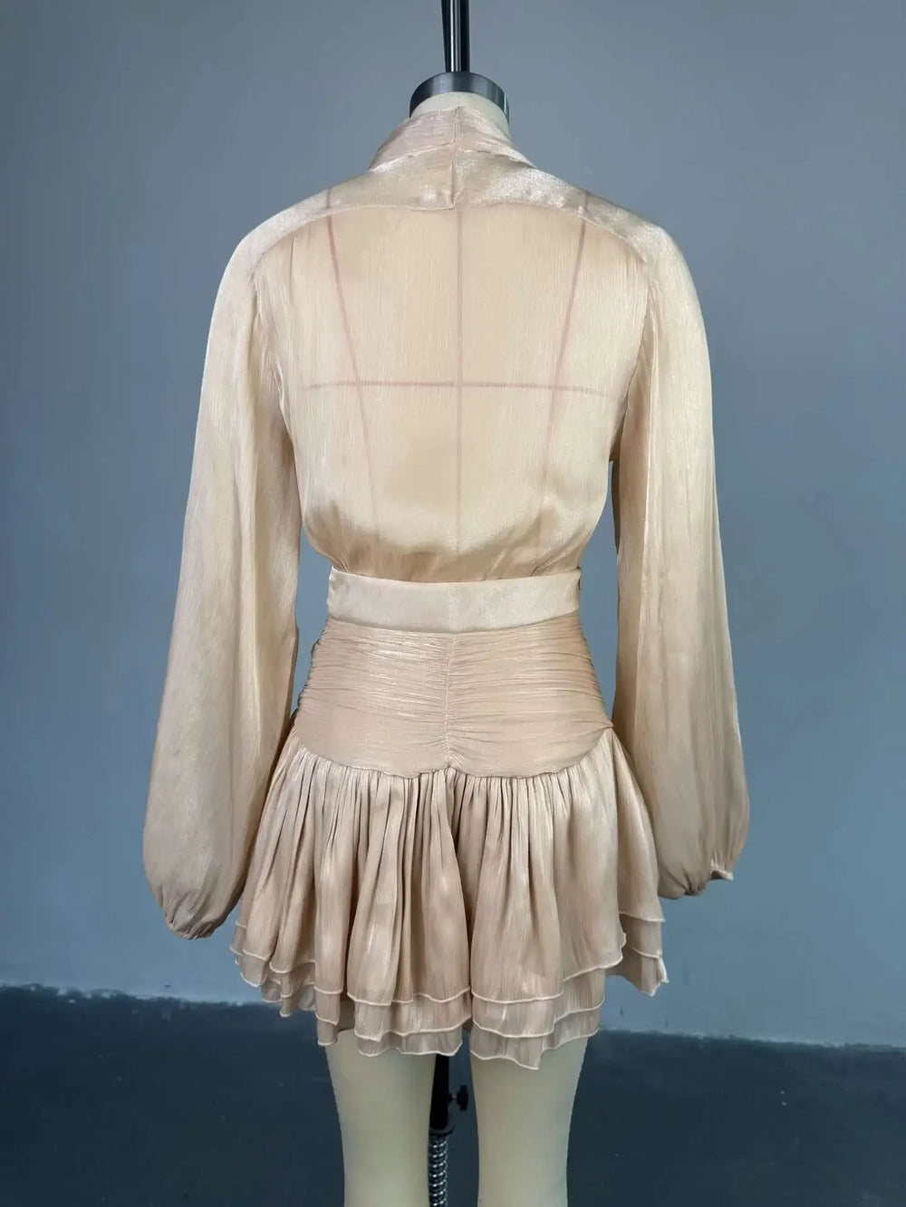 Beige dress on a mannequin against a gray background