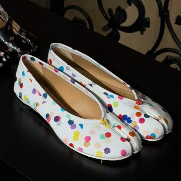 Pair of white patent split-toe flats with colorful polka dots