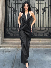 Woman in a black jumpsuit standing in front of an ornate metal gate.