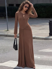 Model wearing a brown twisted neck ruched waist maxi dress with handbag