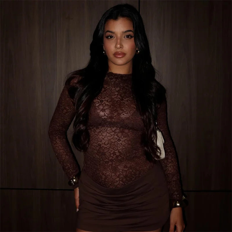 Woman wearing a brown lace dress against a dark background