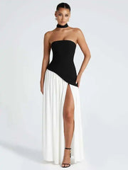 Woman wearing a black and white dress with a high slit on a white background