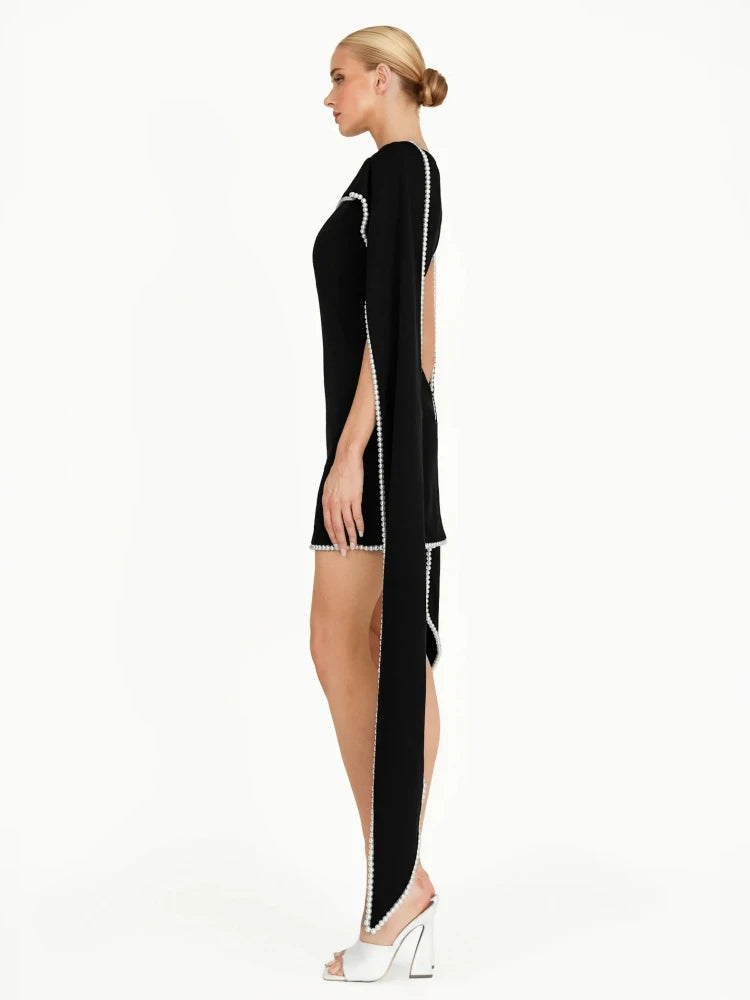 Black dress with white trim worn by a model on a white background