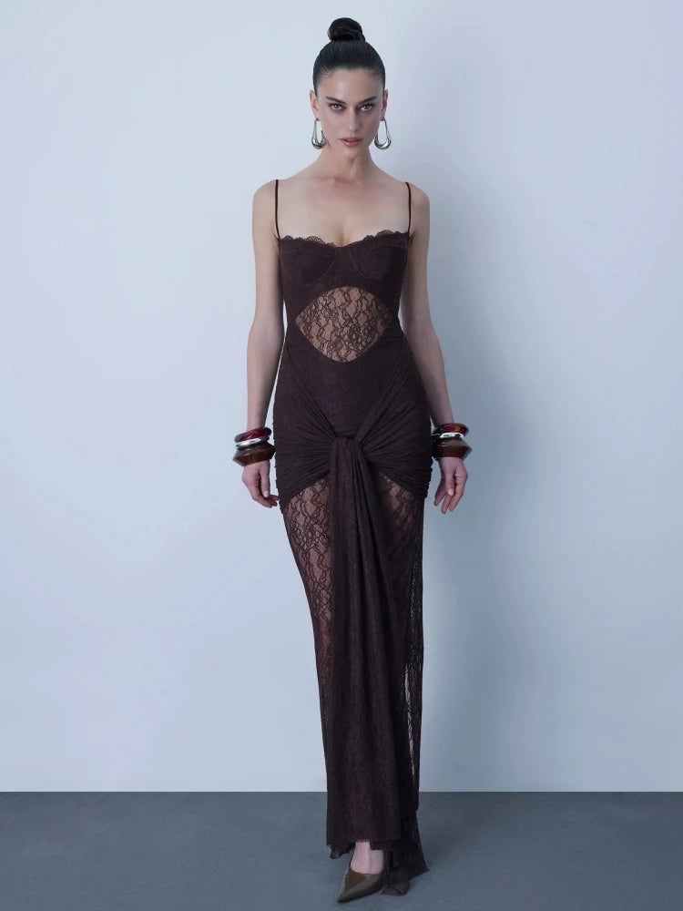 Woman wearing a dark brown evening gown with lace detailing against a plain background