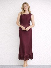 Burgundy sleeveless O-neck maxi dress with fringe trim, hands clasped at the waist.