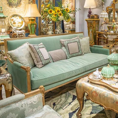 Decorative interior with a green sofa, ornate coffee table, and decorative items.