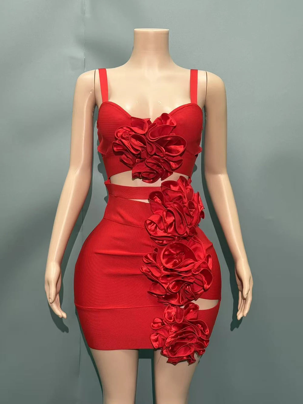 Red dress with floral embellishments on a mannequin against a gray background