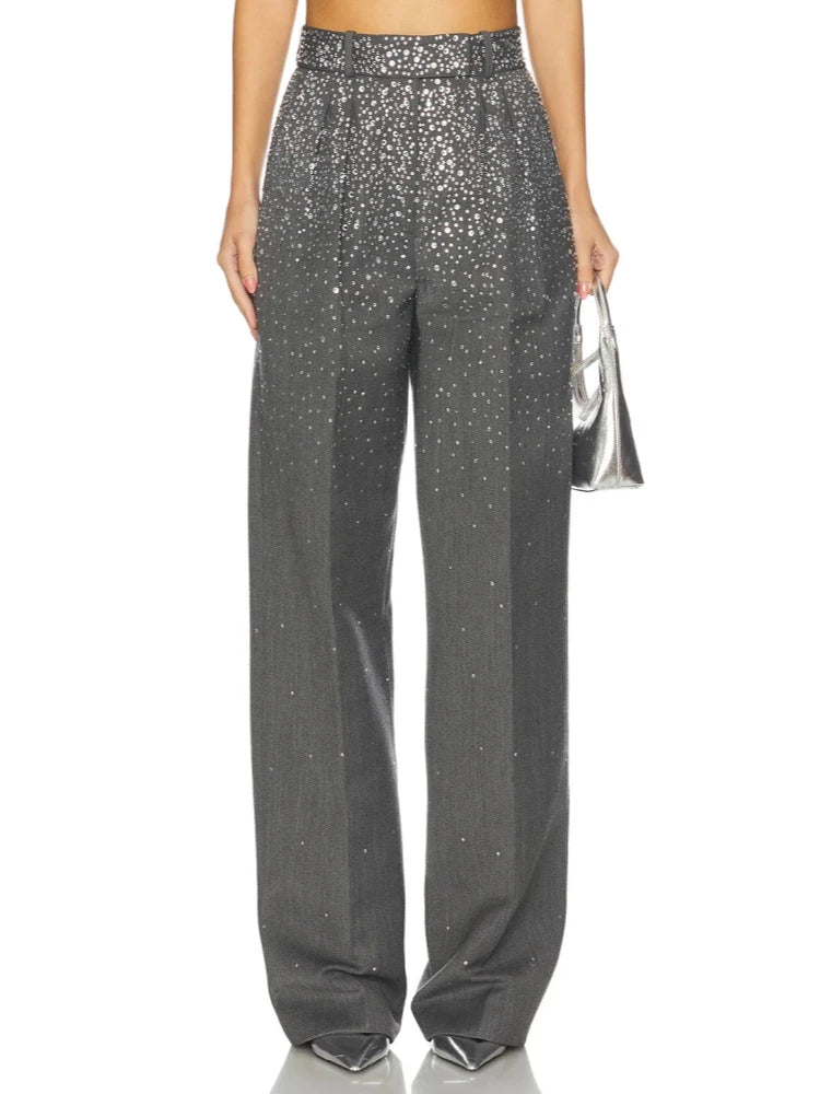 Close-up of the grey crystal-embellished trousers and a silver handbag.