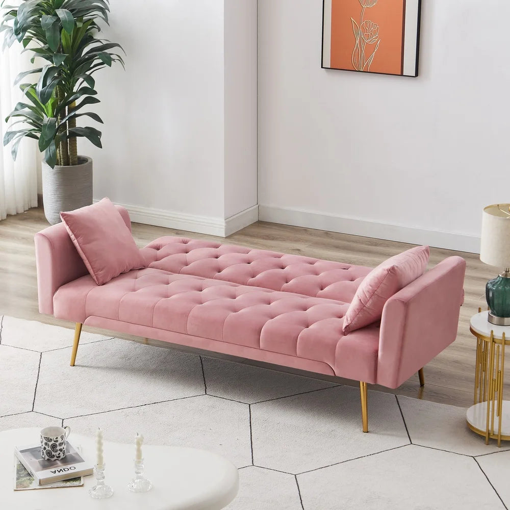Pink tufted sofa in a modern living room with a plant and side table.