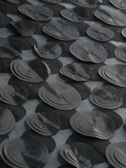Pattern of black circular objects on a textured surface