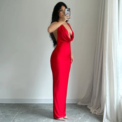 Woman in a red dress taking a mirror selfie against a neutral background