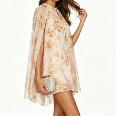 Side view of a woman wearing a floral print cape sleeve mini dress