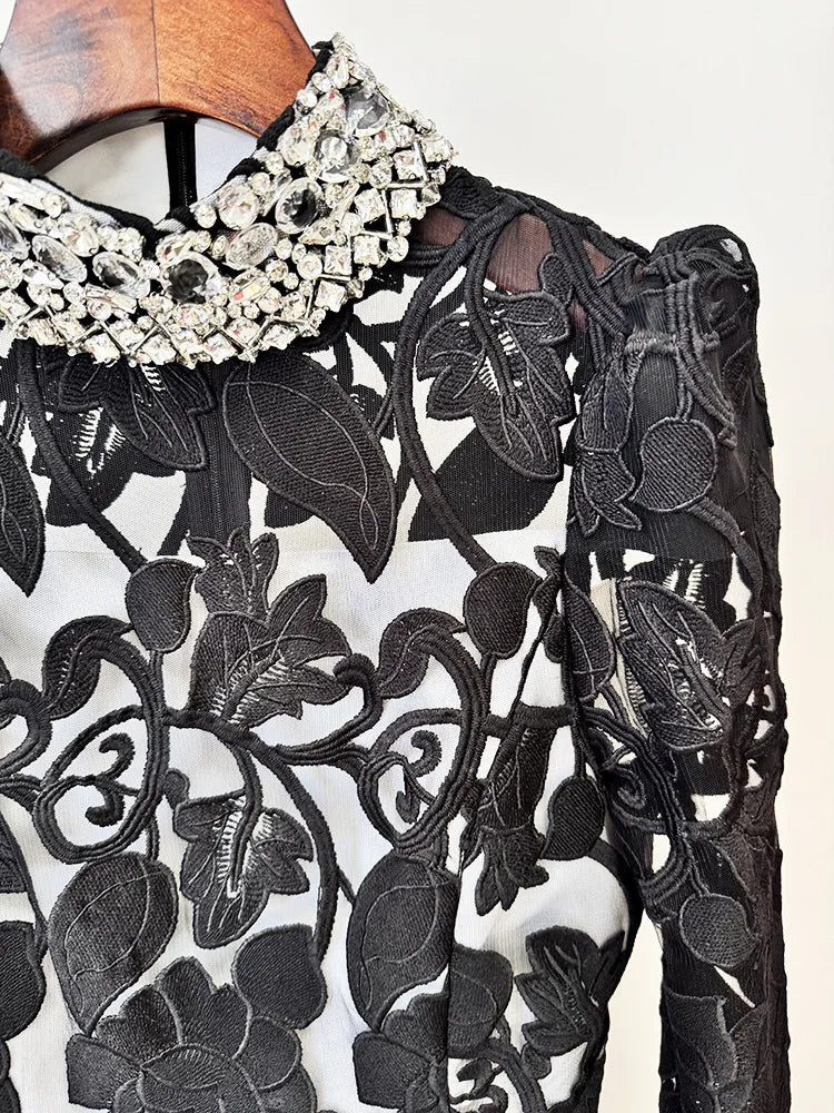 Close-up of the beaded collar and embroidered mesh detail on the black maxi dress.