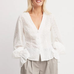 Woman wearing a white blouse with a plain background