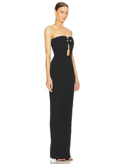 A model wearing a glamorous strapless bandage maxi dress with bead and tassel accents, showcasing its elegant silhouette.