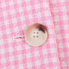 Button on a pink and white checkered fabric
