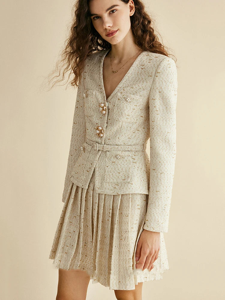 Woman wearing a light-colored dress with a jacket on a beige background