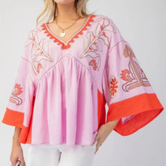 Embroidered V-neck flare sleeve top in pink and orange.