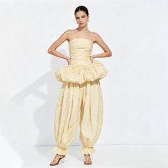 Model posing hands on hips in a strapless ruched top and balloon pants set