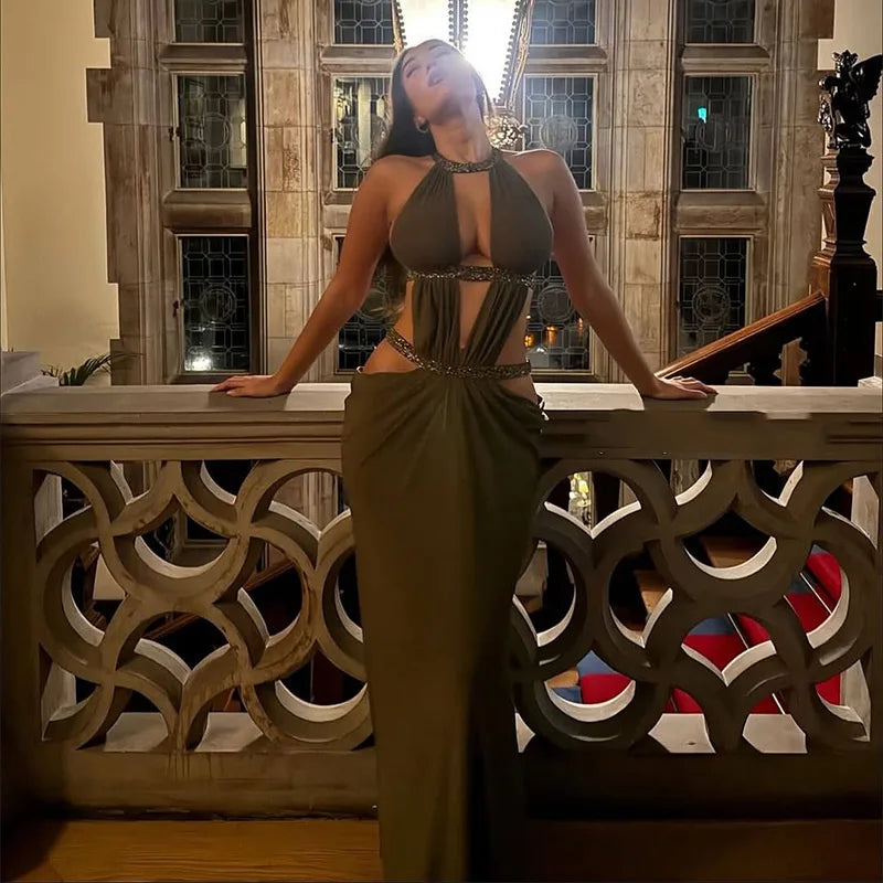 Woman in a green dress standing on a staircase in an elegant interior setting