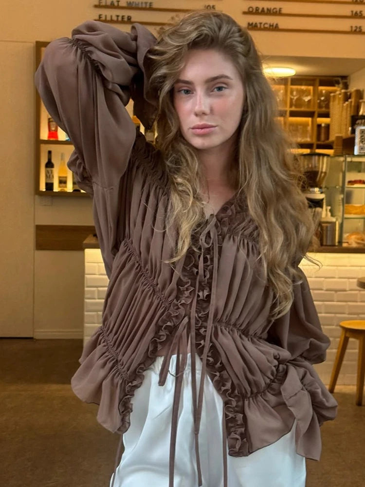 Woman wearing a brown fringed top in a store setting