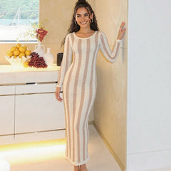 Woman in a striped dress standing in a modern kitchen.