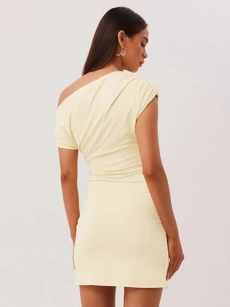 Woman wearing a light yellow dress against a plain background