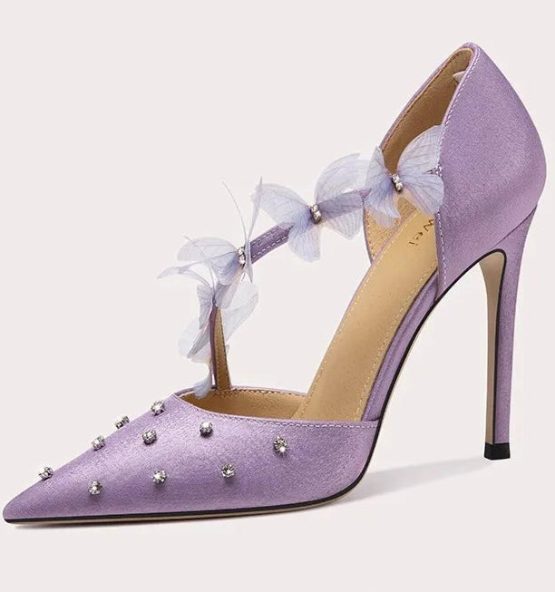 Purple high-heeled shoe with decorative elements on a light gray background