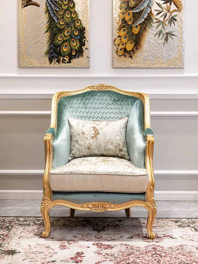 Decorative armchair with gold frame and green cushion in a room with peacock feather artworks on the wall.
