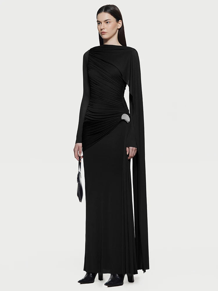 Woman wearing a black dress with long sleeves and a draped design on a white background