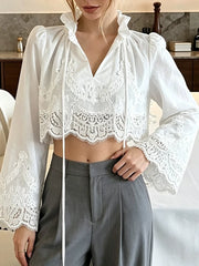 White lace-trimmed cropped blouse with long sleeves and tie-front V-neck