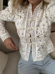 Person wearing a white lace jacket with a neutral background