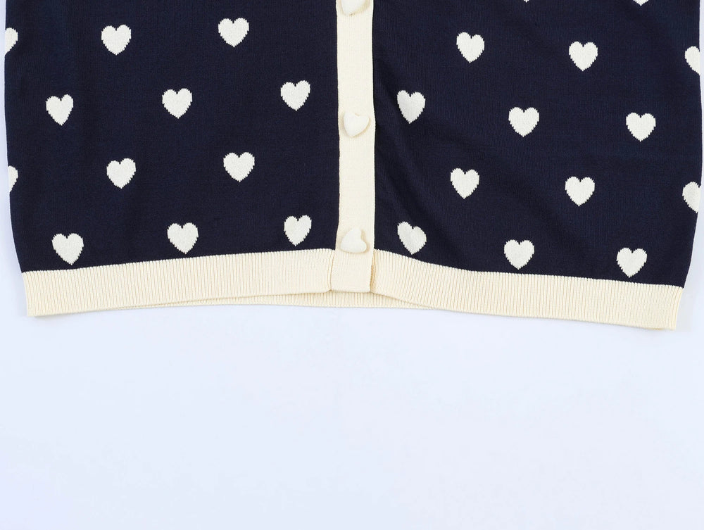 Close-up of the hem and button placket on the navy heart jacquard knit top.
