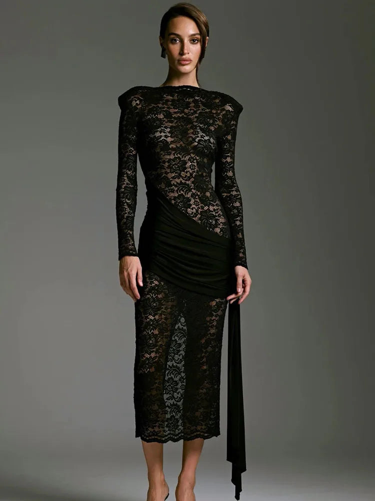 Black lace dress worn by a model on a gray background
