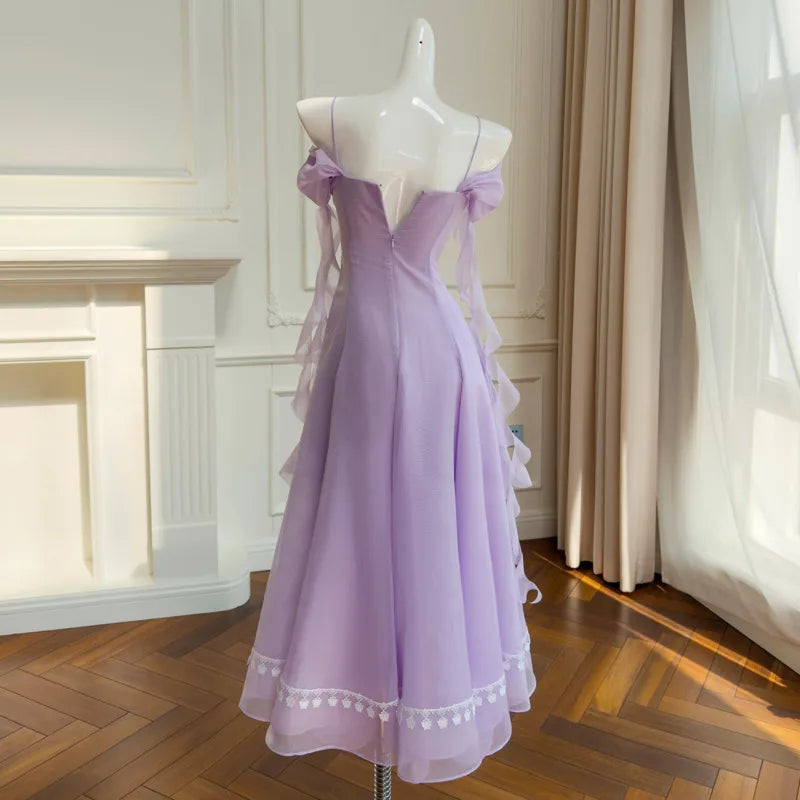 Back view of an off-shoulder gauze A-line midi dress with lace trim and chiffon sleeves.