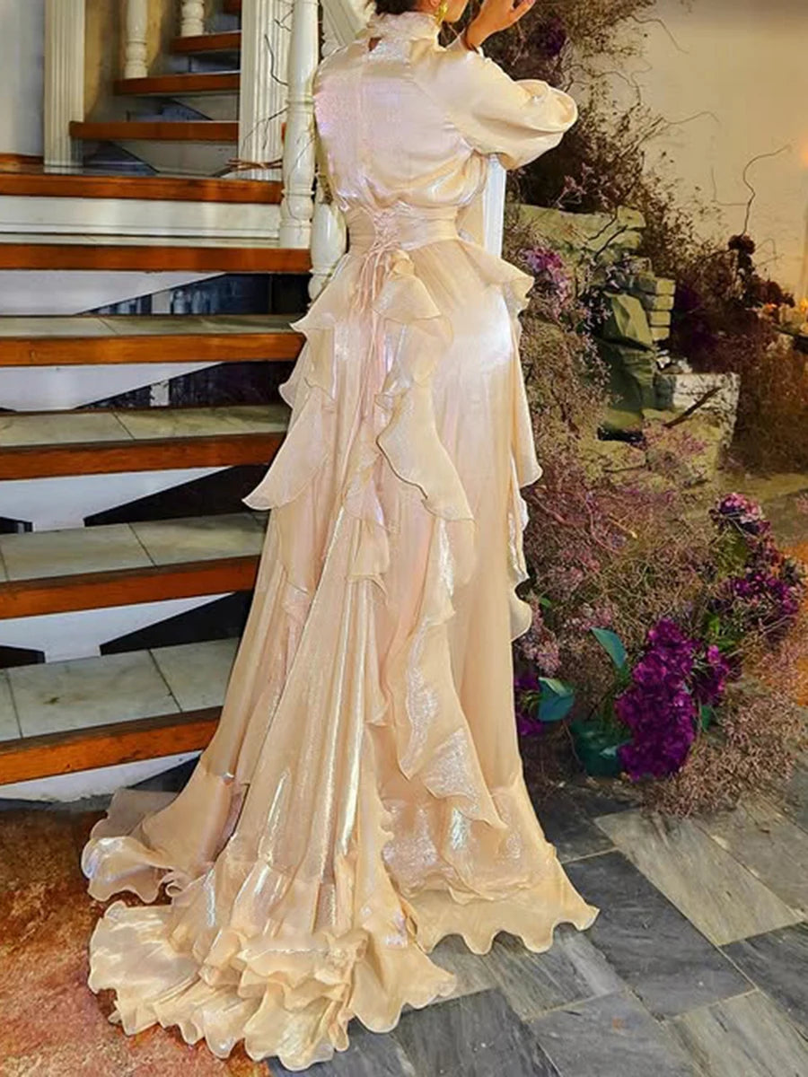 Statue of a woman in an elegant dress standing on a staircase with flowers in the background