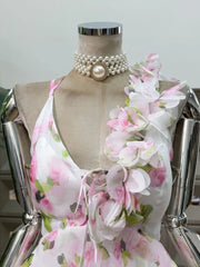 Close-up of the halter neck and bodice embellishments on a floral print mini dress.