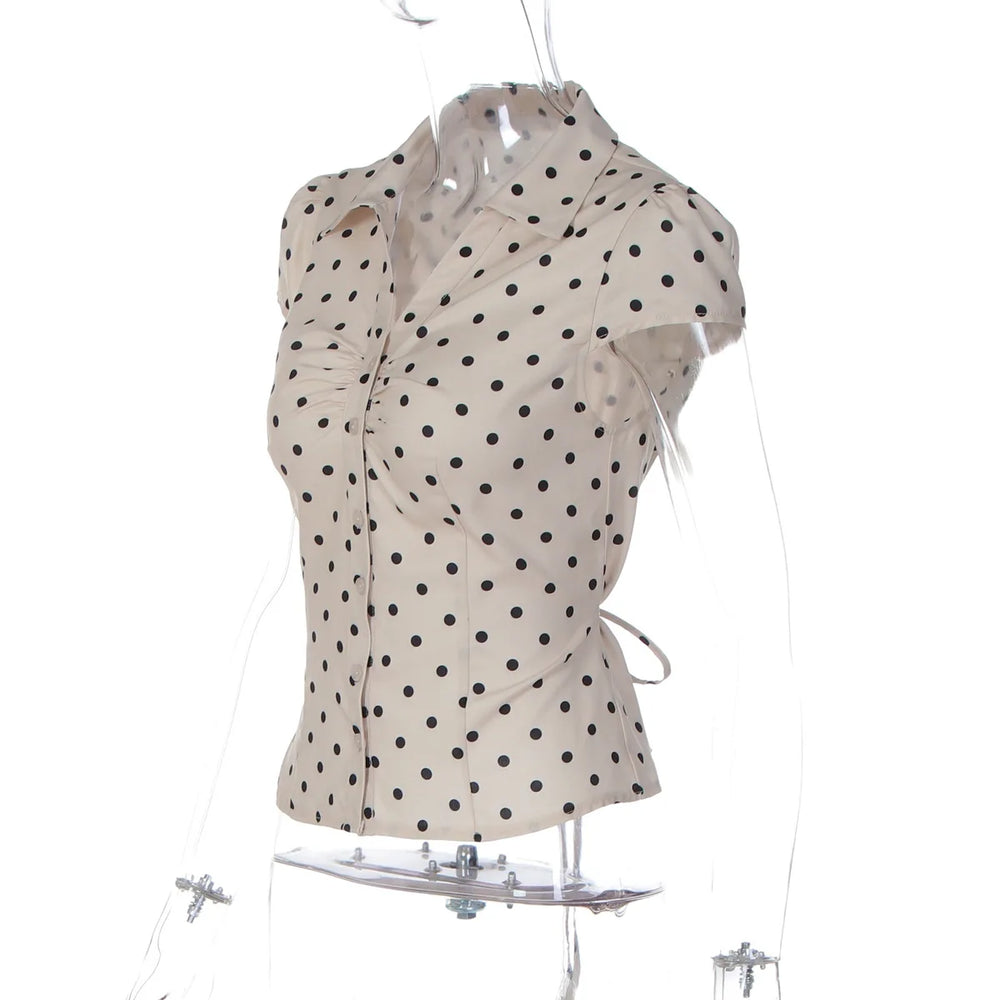 White blouse with black polka dots on a mannequin against a white background