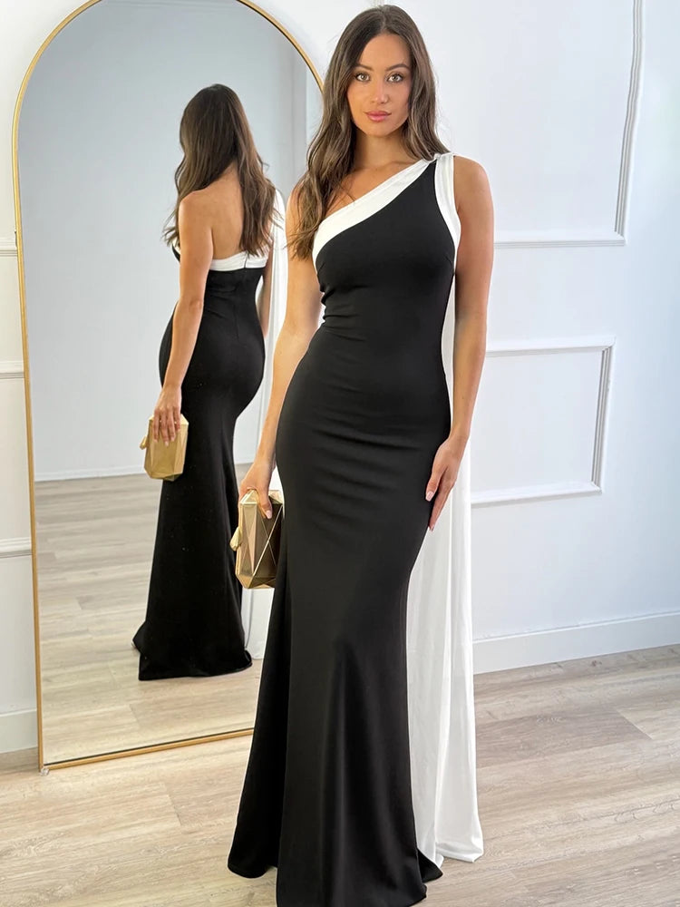Woman wearing a black and white dress standing in front of a mirror.