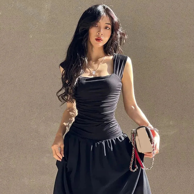 Woman in a black dress holding a handbag against a beige background