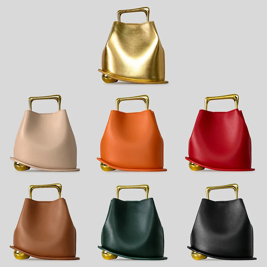 Set of eight handbags in various colors with gold handles on a light gray background
