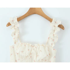 Floral-patterned top on a wooden hanger against a white background