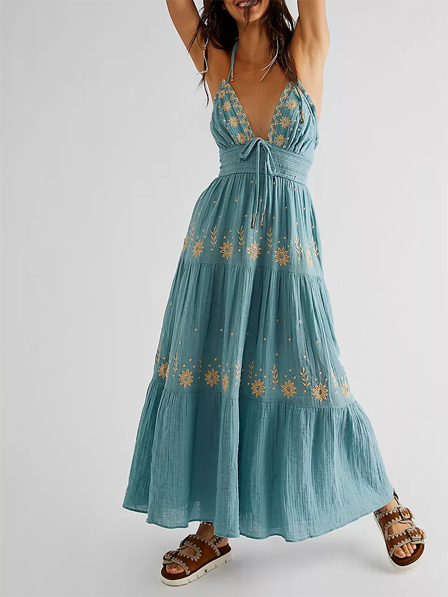 Teal dress with floral embroidery on a white background