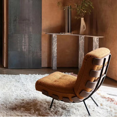 Designer living room chair on white rug and natural light

