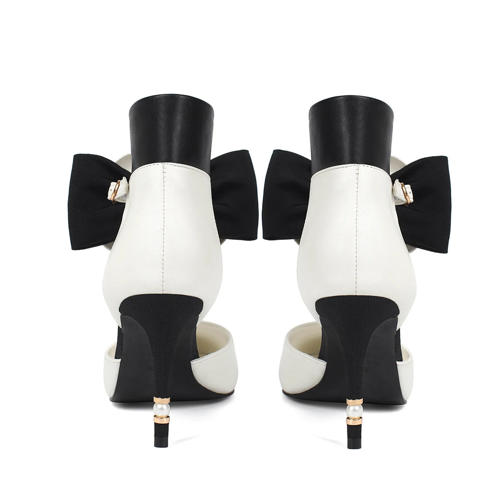 Black and white high-heeled shoes with large bows on a white background