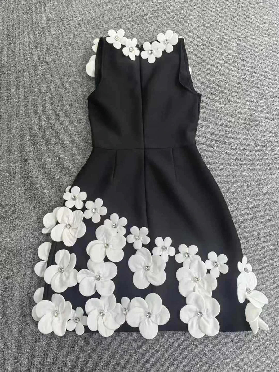 Black dress with white floral embellishments on a gray background
