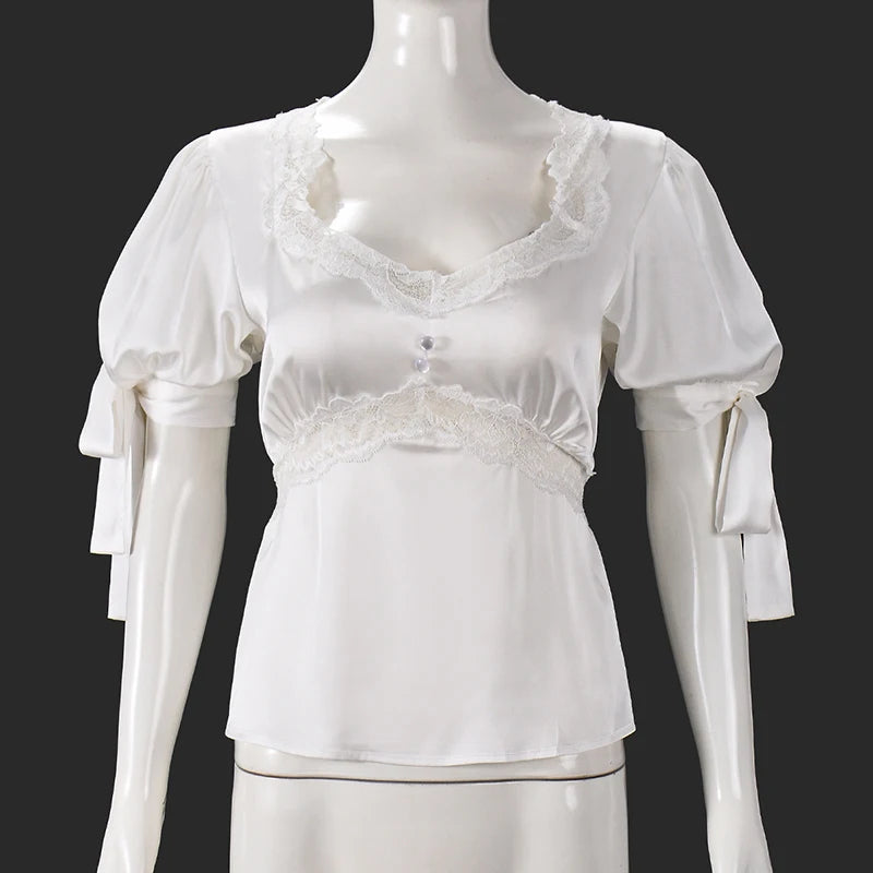 White lace top on a mannequin against a black background