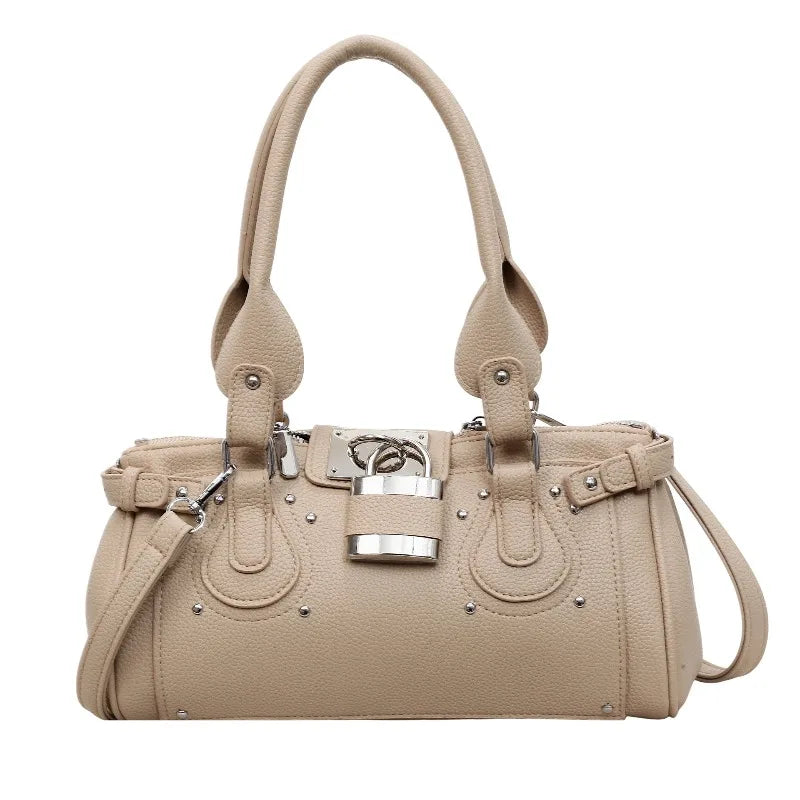 Khaki structured riveted lock bag with top handles and detachable strap.
