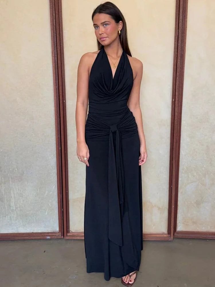 Black halter neck draped maxi dress against a neutral background